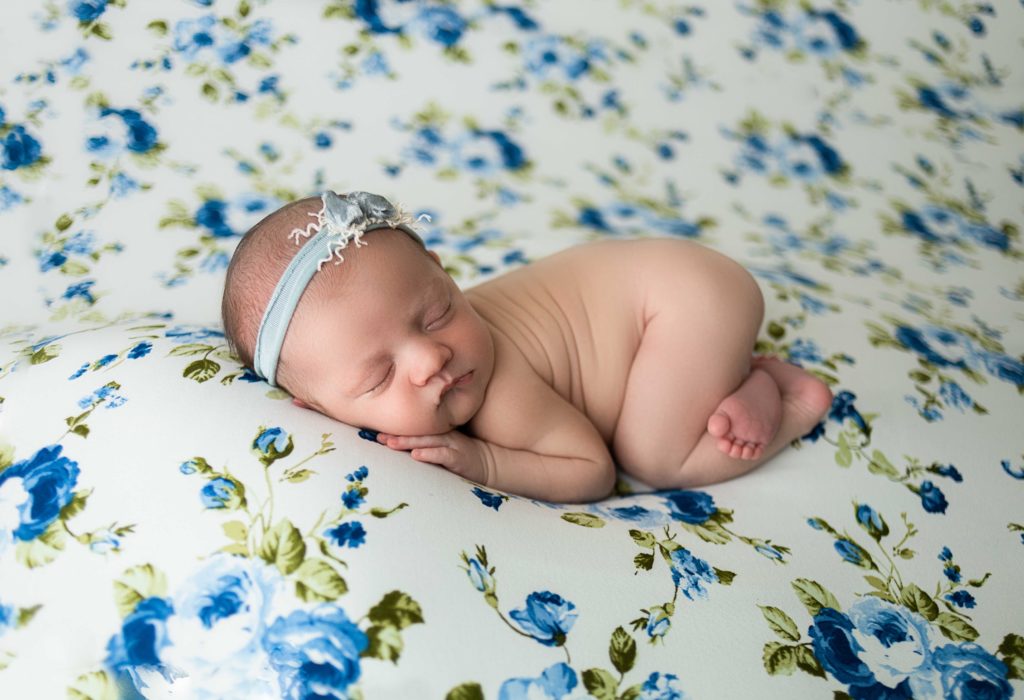 baby girl posed on floral blue and white backdrop